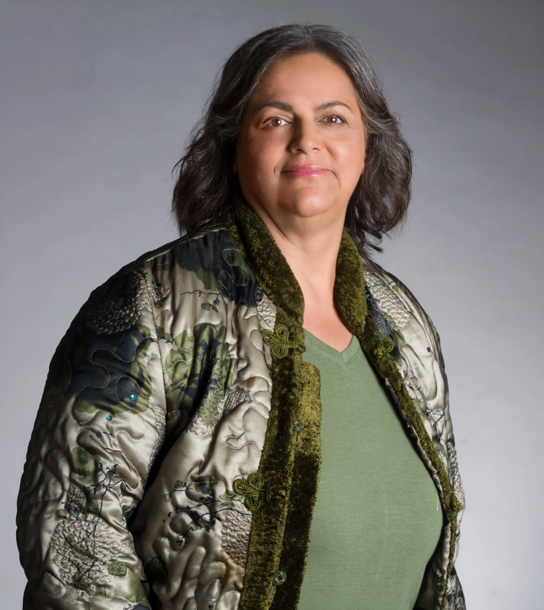 Studio portrait of Esmeralda Reynolds in an ornate green embroidered jacket